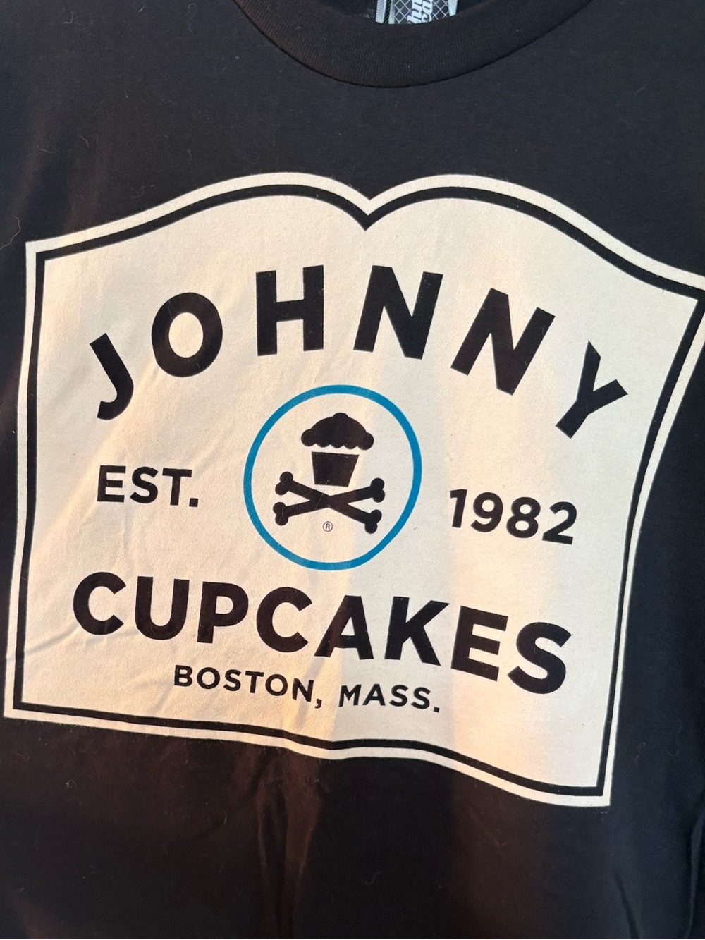 Johnny Cupcakes Black Tee with Cream Logo and Blue Accent Ring